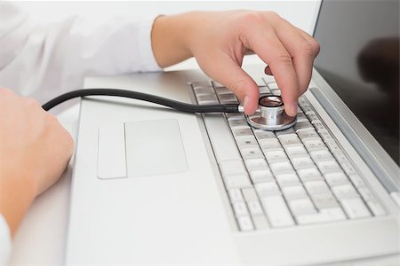 simsearch:400-05244427,k - Technician listening to laptop with stethoscope in his office Stock Photo - Budget Royalty-Free & Subscription, Code: 400-07685497