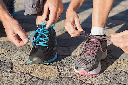 Couple tying their laces of running shoes on a sunny day Stock Photo - Budget Royalty-Free & Subscription, Code: 400-07685679