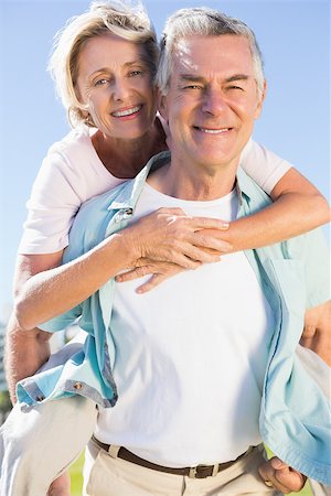 Happy senior man giving his partner a piggy back on a sunny day Stock Photo - Budget Royalty-Free & Subscription, Code: 400-07685754