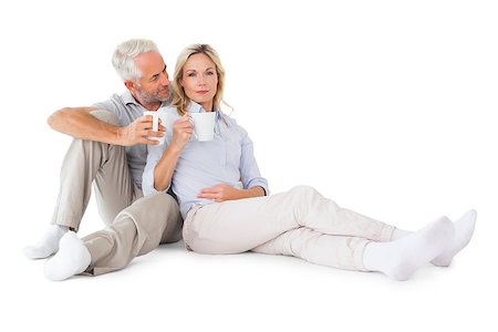 Happy couple sitting holding mugs on white background Stock Photo - Budget Royalty-Free & Subscription, Code: 400-07686177