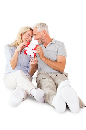 simsearch:400-07686534,k - Happy couple sitting and holding present on white background Foto de stock - Royalty-Free Super Valor e Assinatura, Número: 400-07686171