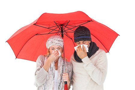 simsearch:400-06888942,k - Couple in winter fashion sneezing under umbrella on white background Photographie de stock - Aubaine LD & Abonnement, Code: 400-07686234