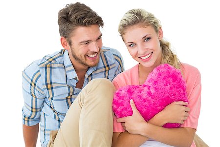 simsearch:400-07686534,k - Attractive young couple sitting holding heart cushion on white background Foto de stock - Royalty-Free Super Valor e Assinatura, Número: 400-07686440