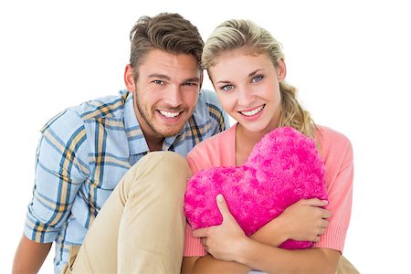 simsearch:400-07686530,k - Attractive young couple sitting holding heart cushion on white background Foto de stock - Royalty-Free Super Valor e Assinatura, Número: 400-07686441
