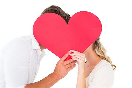 simsearch:400-07686530,k - Attractive young couple kissing behind large heart on white background Foto de stock - Royalty-Free Super Valor e Assinatura, Número: 400-07686519