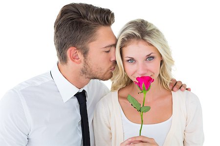 simsearch:400-07686530,k - Handsome man kissing girlfriend on cheek holding a rose on white background Foto de stock - Royalty-Free Super Valor e Assinatura, Número: 400-07686535