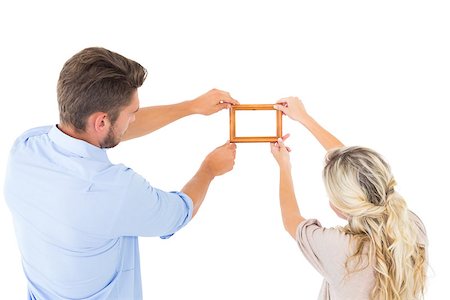 Attractive young couple hanging a frame on white background Stock Photo - Budget Royalty-Free & Subscription, Code: 400-07686570