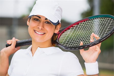 Pretty tennis player smiling at camera on a sunny day Stock Photo - Budget Royalty-Free & Subscription, Code: 400-07686727