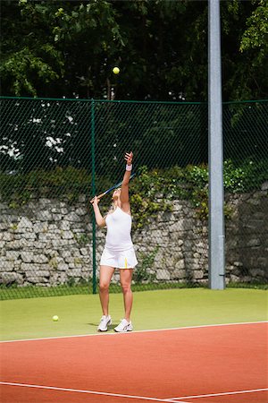 Pretty tennis player serving the ball on a sunny day Photographie de stock - Aubaine LD & Abonnement, Code: 400-07686834