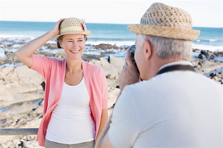 simsearch:693-03707681,k - Happy casual man taking a photo of partner by the sea on a sunny day Foto de stock - Royalty-Free Super Valor e Assinatura, Número: 400-07687579