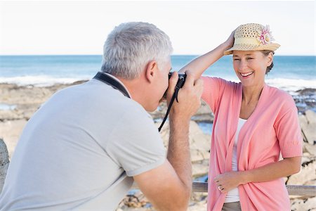 simsearch:693-03707681,k - Happy casual man taking a photo of partner by the sea on a sunny day Foto de stock - Royalty-Free Super Valor e Assinatura, Número: 400-07687582