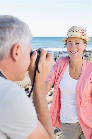 simsearch:693-03707681,k - Happy casual man taking a photo of partner by the sea on a sunny day Foto de stock - Royalty-Free Super Valor e Assinatura, Número: 400-07687583