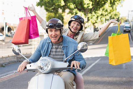 Happy mature couple riding a scooter in the city on a sunny day Stock Photo - Budget Royalty-Free & Subscription, Code: 400-07687769