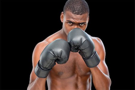 defensive posture - Portrait of a shirtless muscular boxer in defensive stance over black background Foto de stock - Super Valor sin royalties y Suscripción, Código: 400-07687998