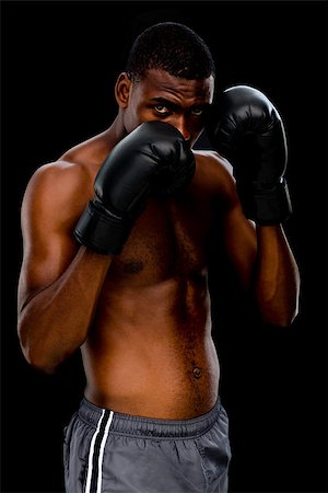 defensive posture - Portrait of a shirtless muscular boxer in defensive stance over black background Foto de stock - Super Valor sin royalties y Suscripción, Código: 400-07688000