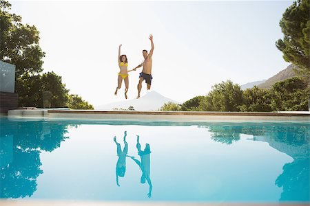 Full length of a cheerful young couple jumping into swimming pool Stock Photo - Budget Royalty-Free & Subscription, Code: 400-07688293