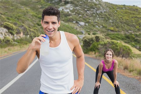 simsearch:400-07688341,k - Portrait of a fit young couple standing on the open road together Stock Photo - Budget Royalty-Free & Subscription, Code: 400-07688344