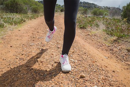 simsearch:400-07688341,k - Low section of fit young woman running on country road Stock Photo - Budget Royalty-Free & Subscription, Code: 400-07688435