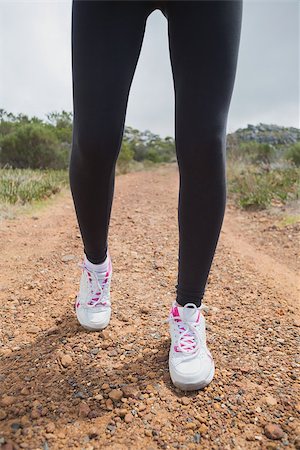 simsearch:400-07688341,k - Low section of fit young woman walking on country road Stock Photo - Budget Royalty-Free & Subscription, Code: 400-07688436