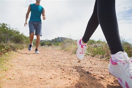 simsearch:400-07688341,k - Low angle view of fit young couple running on countryside road Stock Photo - Budget Royalty-Free & Subscription, Code: 400-07688442