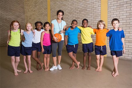 simsearch:400-07684082,k - Cute pupils smiling at camera with PE teacher at the elementary school Stock Photo - Budget Royalty-Free & Subscription, Code: 400-07688831