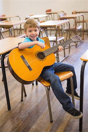 simsearch:400-07991069,k - Cute pupil playing guitar in classroom at the elementary school Foto de stock - Royalty-Free Super Valor e Assinatura, Número: 400-07688884