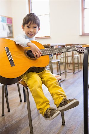 simsearch:400-07991069,k - Cute pupil playing guitar in classroom at the elementary school Foto de stock - Royalty-Free Super Valor e Assinatura, Número: 400-07688886