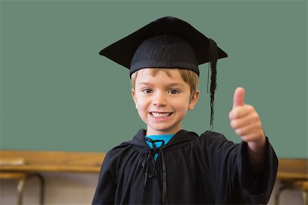 school kids graduate - Cute pupil in graduation robe smiling at camera in classroom at the elementary school Stock Photo - Budget Royalty-Free & Subscription, Code: 400-07688881