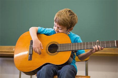 simsearch:400-07991069,k - Cute pupil playing guitar in classroom at the elementary school Foto de stock - Royalty-Free Super Valor e Assinatura, Número: 400-07688883