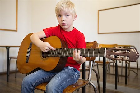 simsearch:400-07991069,k - Cute pupil playing guitar in classroom at the elementary school Foto de stock - Royalty-Free Super Valor e Assinatura, Número: 400-07688916