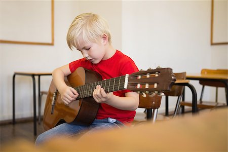 simsearch:400-07991069,k - Cute pupil playing guitar in classroom at the elementary school Foto de stock - Royalty-Free Super Valor e Assinatura, Número: 400-07688917