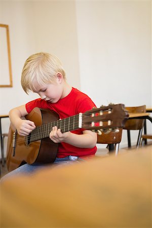 simsearch:400-07991069,k - Cute pupil playing guitar in classroom at the elementary school Foto de stock - Royalty-Free Super Valor e Assinatura, Número: 400-07688918