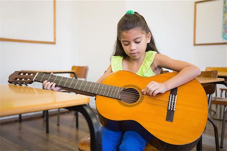 simsearch:400-07991069,k - Cute pupil playing guitar in classroom at the elementary school Foto de stock - Royalty-Free Super Valor e Assinatura, Número: 400-07688910