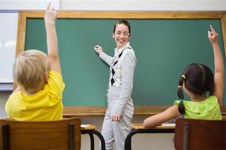 simsearch:400-07684082,k - Pretty teacher writing on chalkboard at the elementary school Stock Photo - Budget Royalty-Free & Subscription, Code: 400-07688987