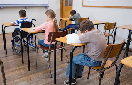simsearch:400-07991158,k - Disabled pupil writing at desk in classroom at the elementary school Stock Photo - Budget Royalty-Free & Subscription, Code: 400-07688995