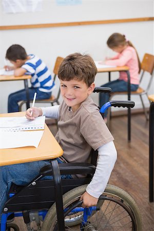 Disabled pupil writing at desk in classroom at the elementary school Stock Photo - Budget Royalty-Free & Subscription, Code: 400-07689002