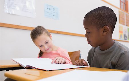 simsearch:400-07991069,k - Cute pupils reading at their desks at the elementary school Foto de stock - Royalty-Free Super Valor e Assinatura, Número: 400-07689026