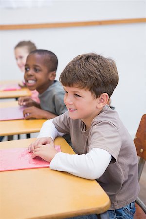 simsearch:400-07991069,k - Cute pupils listening attentively in classroom at the elementary school Foto de stock - Royalty-Free Super Valor e Assinatura, Número: 400-07689021