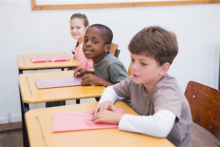 simsearch:400-07991069,k - Cute pupils listening attentively in classroom at the elementary school Foto de stock - Royalty-Free Super Valor e Assinatura, Número: 400-07689022