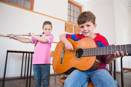 simsearch:400-07991069,k - Cute pupils playing flute and guitar in classroom at the elementary school Foto de stock - Royalty-Free Super Valor e Assinatura, Número: 400-07689036