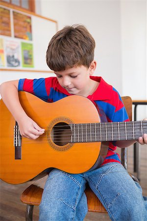 simsearch:400-07991069,k - Cute pupil playing guitar in classroom at the elementary school Foto de stock - Royalty-Free Super Valor e Assinatura, Número: 400-07689037