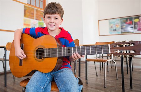 simsearch:400-07991069,k - Cute pupil playing guitar in classroom at the elementary school Foto de stock - Royalty-Free Super Valor e Assinatura, Número: 400-07689038