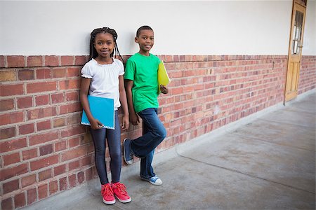 simsearch:400-07991158,k - Cute pupils smiling at camera in corridor at the elementary school Stock Photo - Budget Royalty-Free & Subscription, Code: 400-07689056