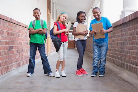 simsearch:400-07991158,k - Cute pupils smiling at camera in hallway at the elementary school Stock Photo - Budget Royalty-Free & Subscription, Code: 400-07689074