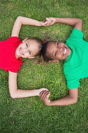 Cute children smiling at camera outside on the grass in the park Stock Photo - Budget Royalty-Free & Subscription, Code: 400-07689099