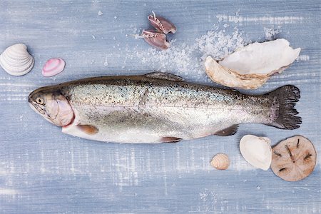 Fresh trout with various seashell and sea salt crystals on blue wooden background, top view. Luxurious mediterranean seafood eating background. Stock Photo - Budget Royalty-Free & Subscription, Code: 400-07681051
