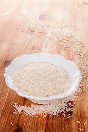 simsearch:400-05744487,k - Traditional asian rice eating. Raw rice in white bowl in brown wooden background. Culinary healthy rice eating. Stock Photo - Budget Royalty-Free & Subscription, Code: 400-07681107