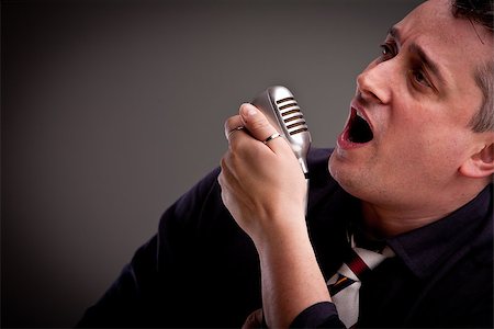 simsearch:400-07681481,k - a fifties style singer is singing with an old microphone in his hand Foto de stock - Super Valor sin royalties y Suscripción, Código: 400-07681483