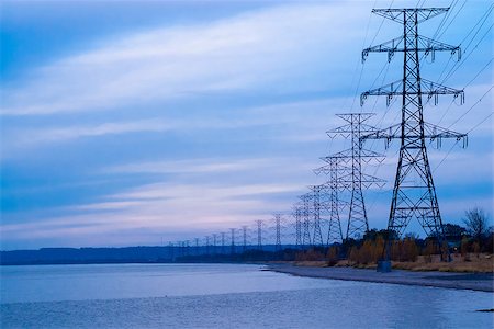 Row of large electrical towers receding into distance by shore. Fotografie stock - Microstock e Abbonamento, Codice: 400-07682720