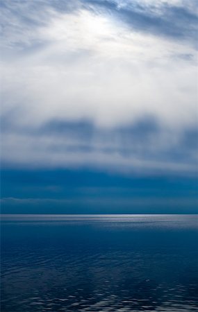 Sun rays and bright clouds above dark water. Fotografie stock - Microstock e Abbonamento, Codice: 400-07682721